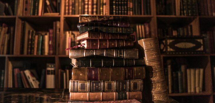 Books piled on a wooden shelf