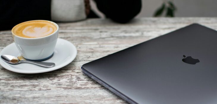 A laptop beside latte art